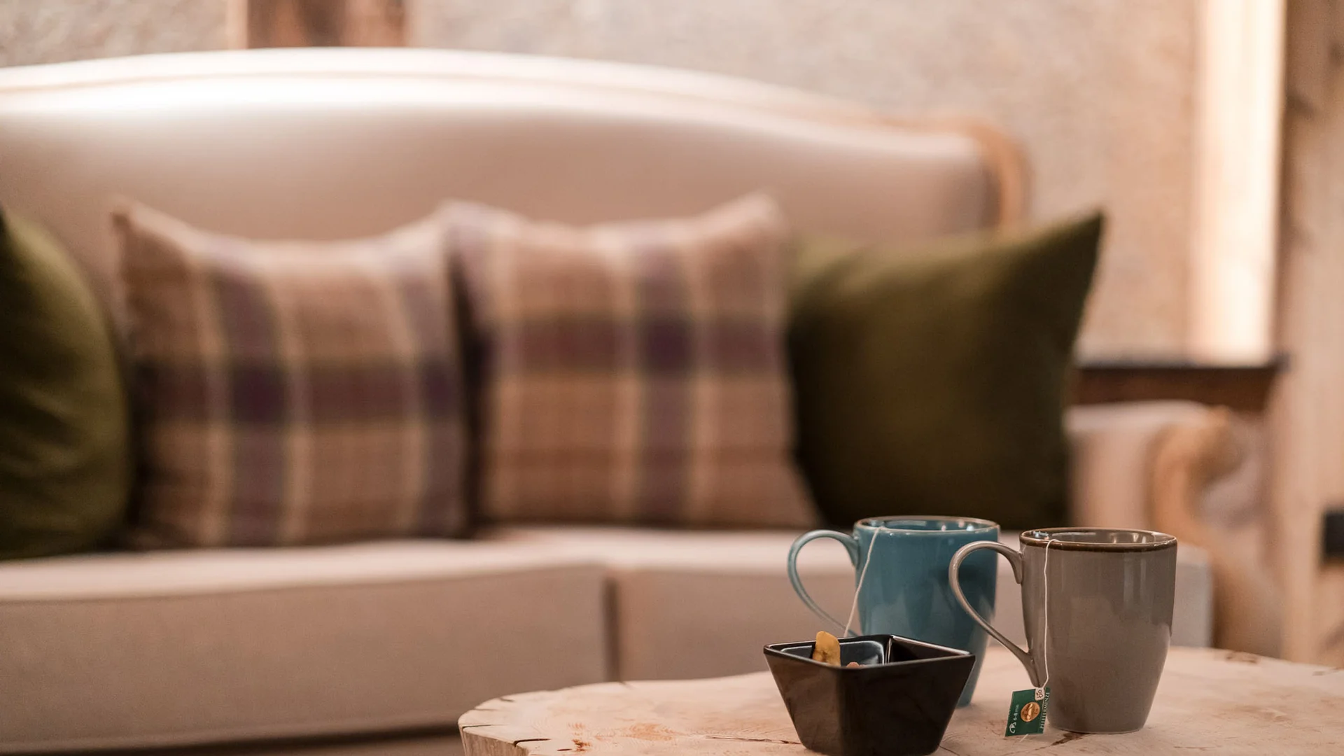 Bilder aus Arabba des Chalet Barbara Zwei Teetassen und eine Schale auf einem Tisch vor einem Sofa mit Kissen