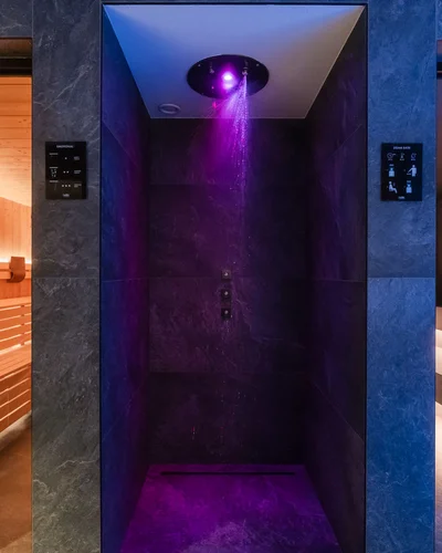 Dein Chalet-Hotel mit Wellness in den Dolomiten Farbtherapie-Dusche mit violettem Licht zwischen zwei Saunen