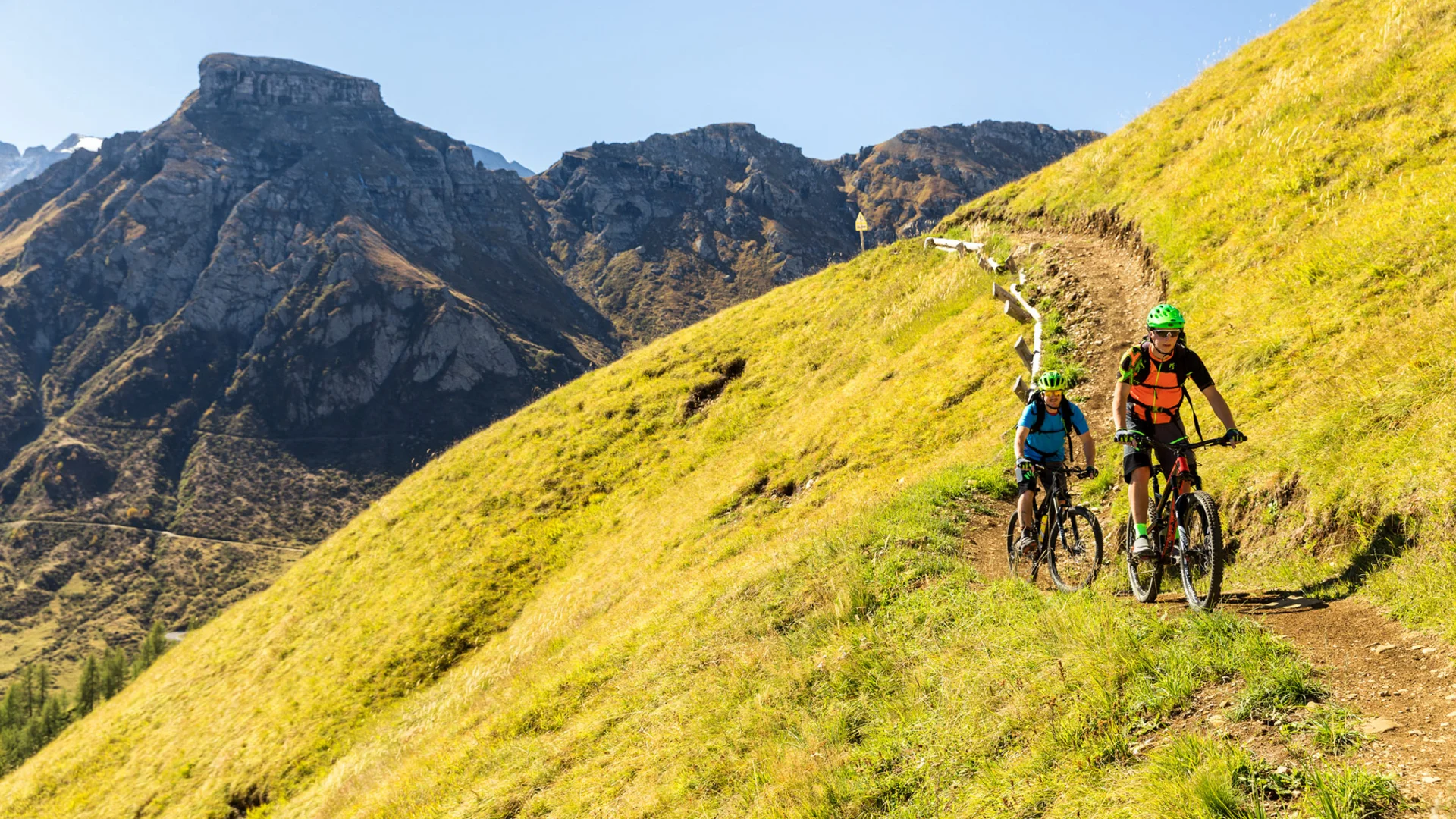 Bilder aus Arabba des Chalet Barbara Zwei Radfahrer mit Helm auf bergigem Grasweg vor Bergkulisse