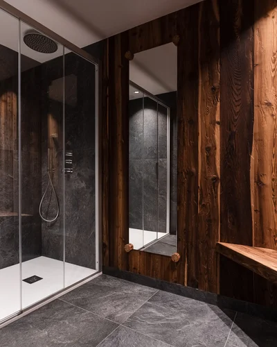 Dein Chalet-Hotel mit Wellness in den Dolomiten Moderne Dusche mit Steinwänden und dunklen Holzwänden im Badezimmer