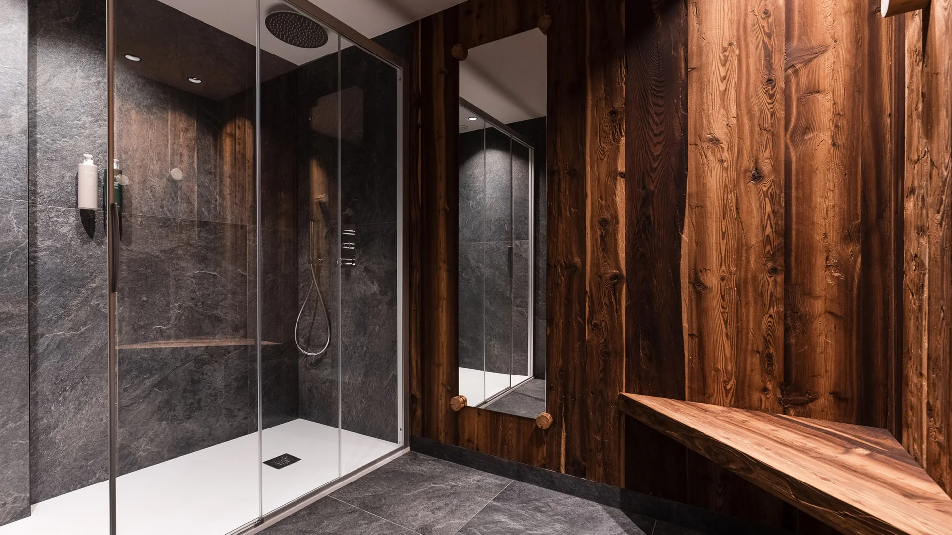 Bilder aus Arabba des Chalet Barbara Moderne Dusche mit Steinwänden und dunklen Holzwänden im Badezimmer