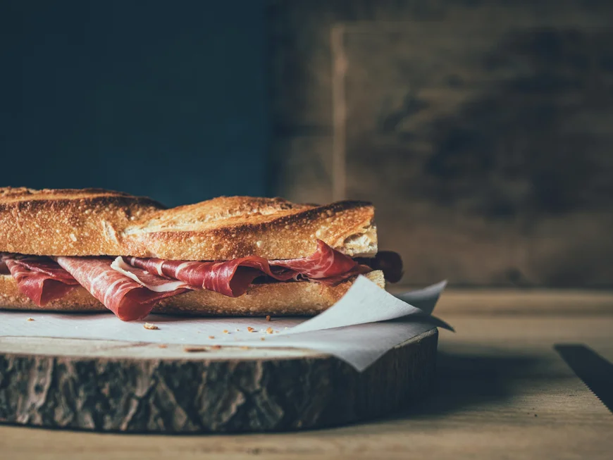 Sandwich mit Salami auf rustikalem Holzbrett