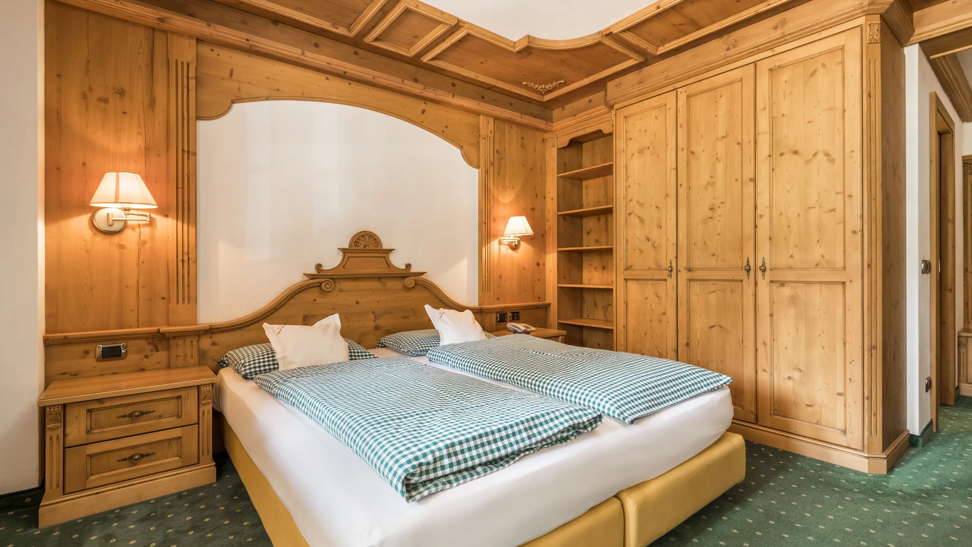 Bilder aus Arabba des Chalet Barbara Schlafzimmer mit Doppelbett und hellen Holzmöbeln