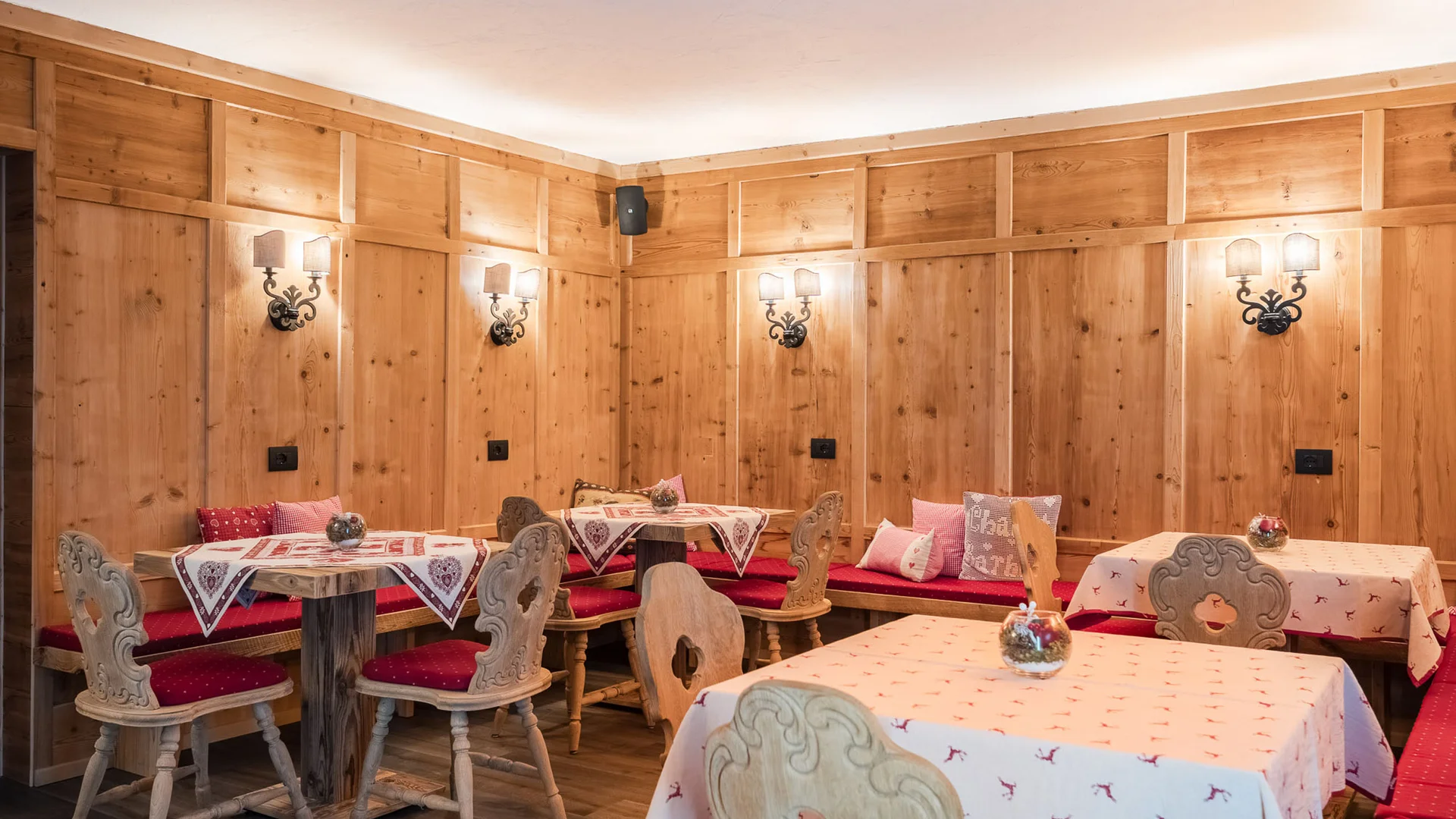 Bilder aus Arabba des Chalet Barbara Rustikaler Speiseraum mit Holztischen, Stühlen und Holzvertäfelung