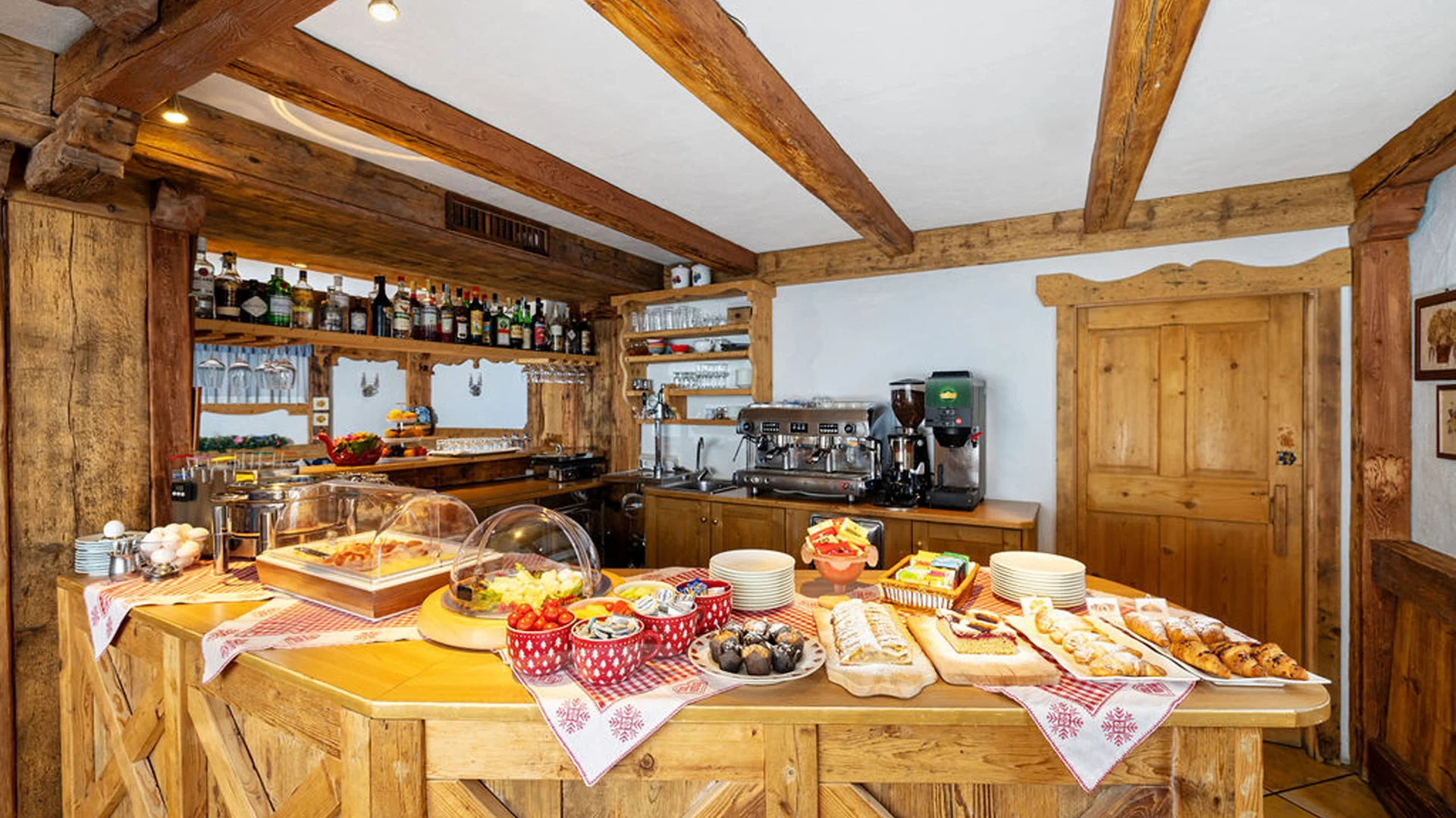 Bilder aus Arabba des Chalet Barbara Frühstücksbuffet mit Gebäck und Getränken in rustikalem Holzbar