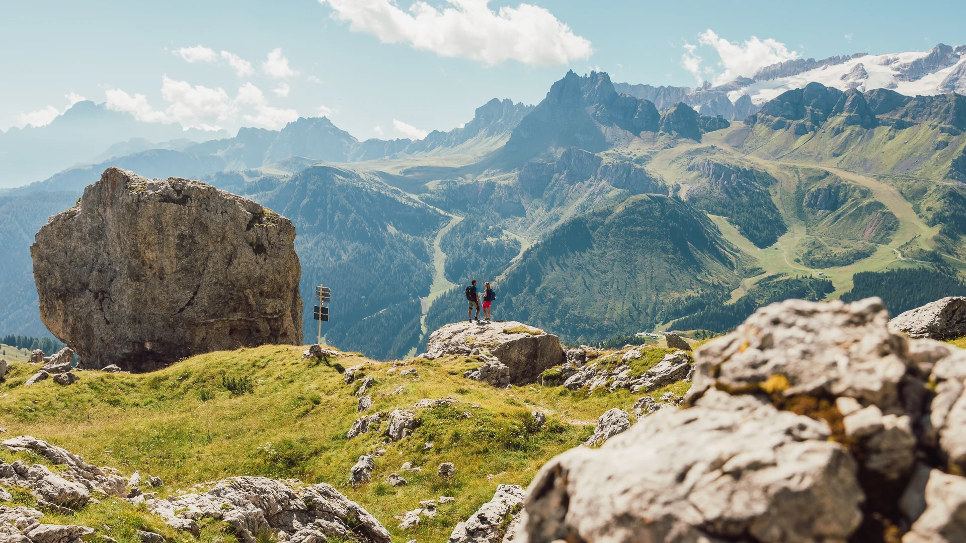 Bilder aus Arabba des Chalet Barbara Zwei Wanderer auf einem Felsen mit Bergblick und klarem Himmel