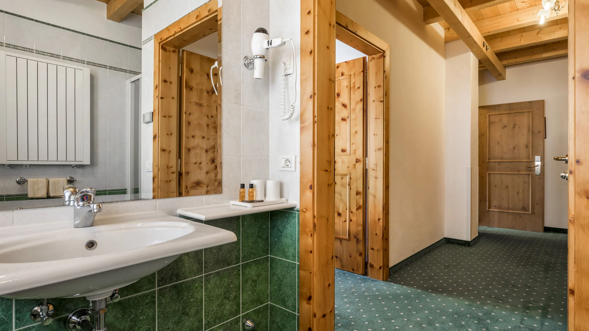 Bilder aus Arabba des Chalet Barbara Waschbecken mit grünen Fliesen und Flur mit Holztüren