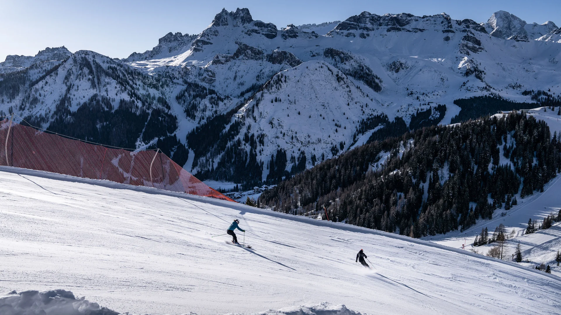 Bilder aus Arabba des Chalet Barbara Skifahrer fahren eine verschneite Piste mit verschneiten Bergen im Hintergrund hinunter