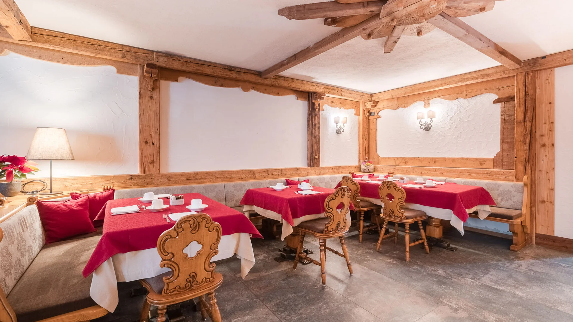 Bilder aus Arabba des Chalet Barbara Rustikaler Speiseraum mit roten Tischdecken und geschnitzten Holzstühlen