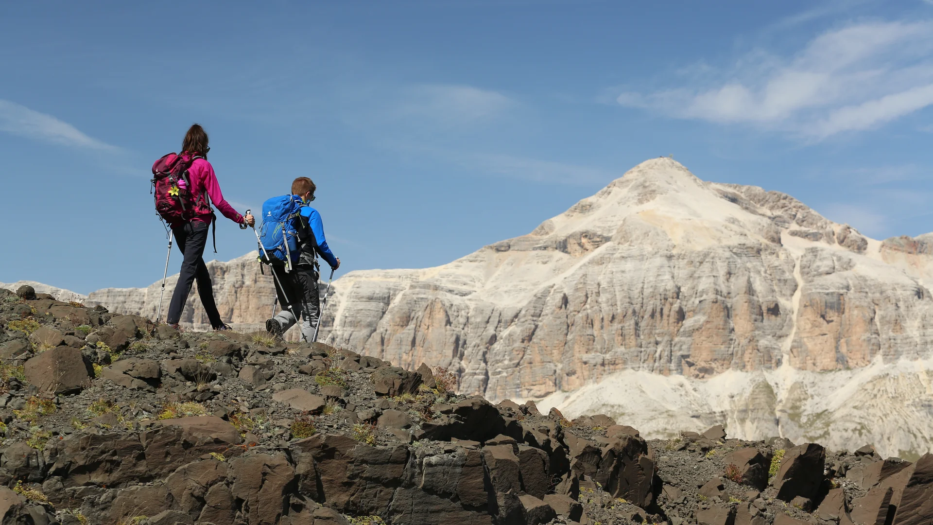 Bilder aus Arabba des Chalet Barbara Zwei Wanderer mit Rucksäcken und Wanderstöcken auf Felsen vor Berg
