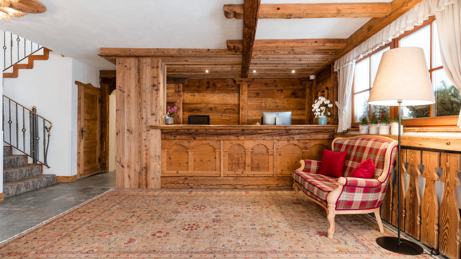 Rustic wooden reception area with plaid sofa and floor lamp