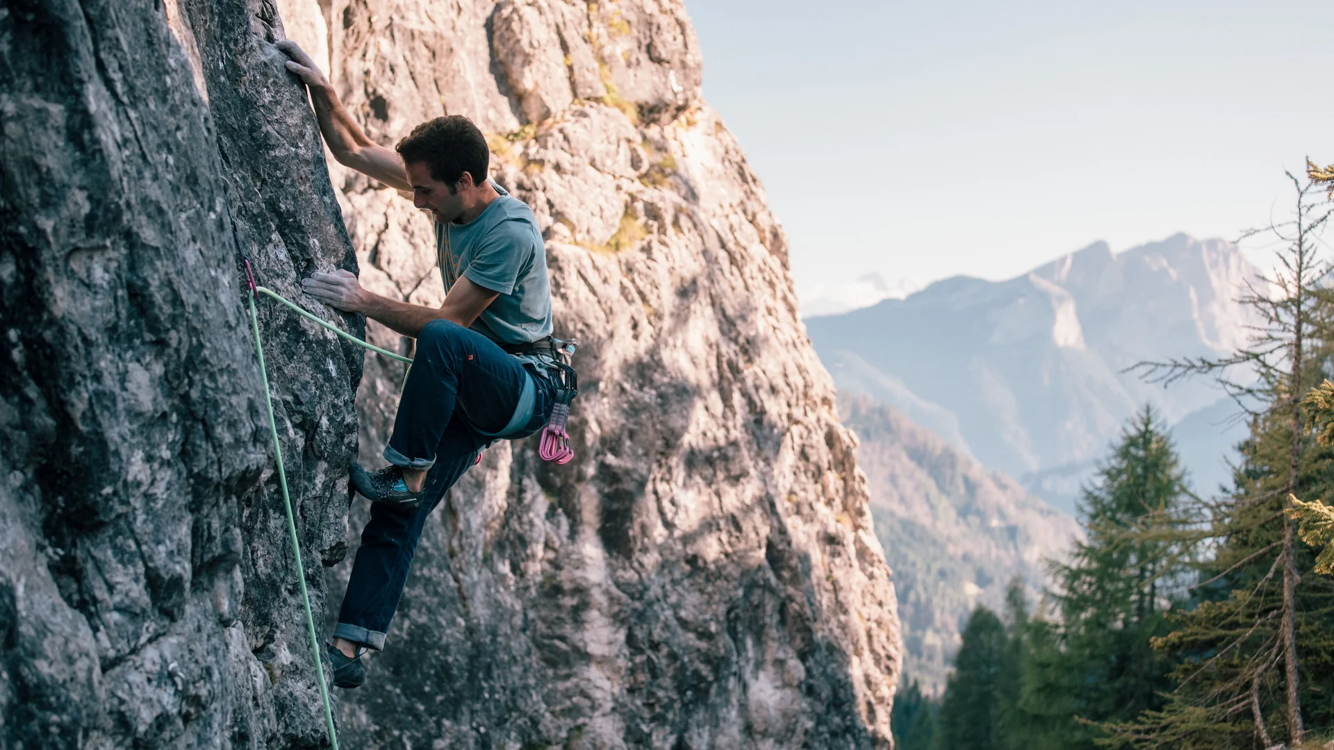 Bilder aus Arabba des Chalet Barbara Mann beim Klettern an einem Felsen mit Alpenlandschaft im Hintergrund