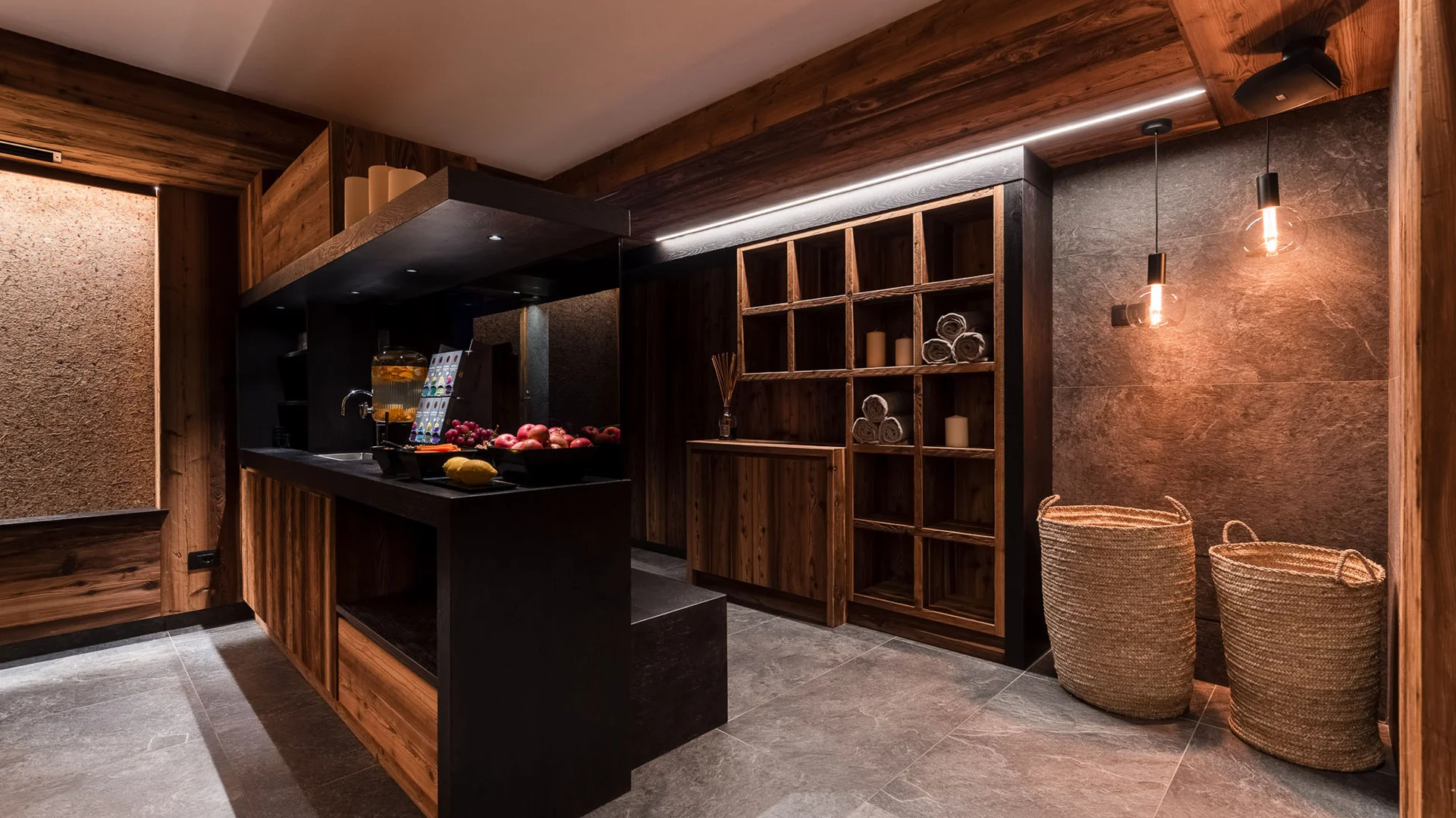 Bilder aus Arabba des Chalet Barbara Innenraum eines Wellnessbereichs mit Holzregalen, Körben und gedämpfter Beleuchtung