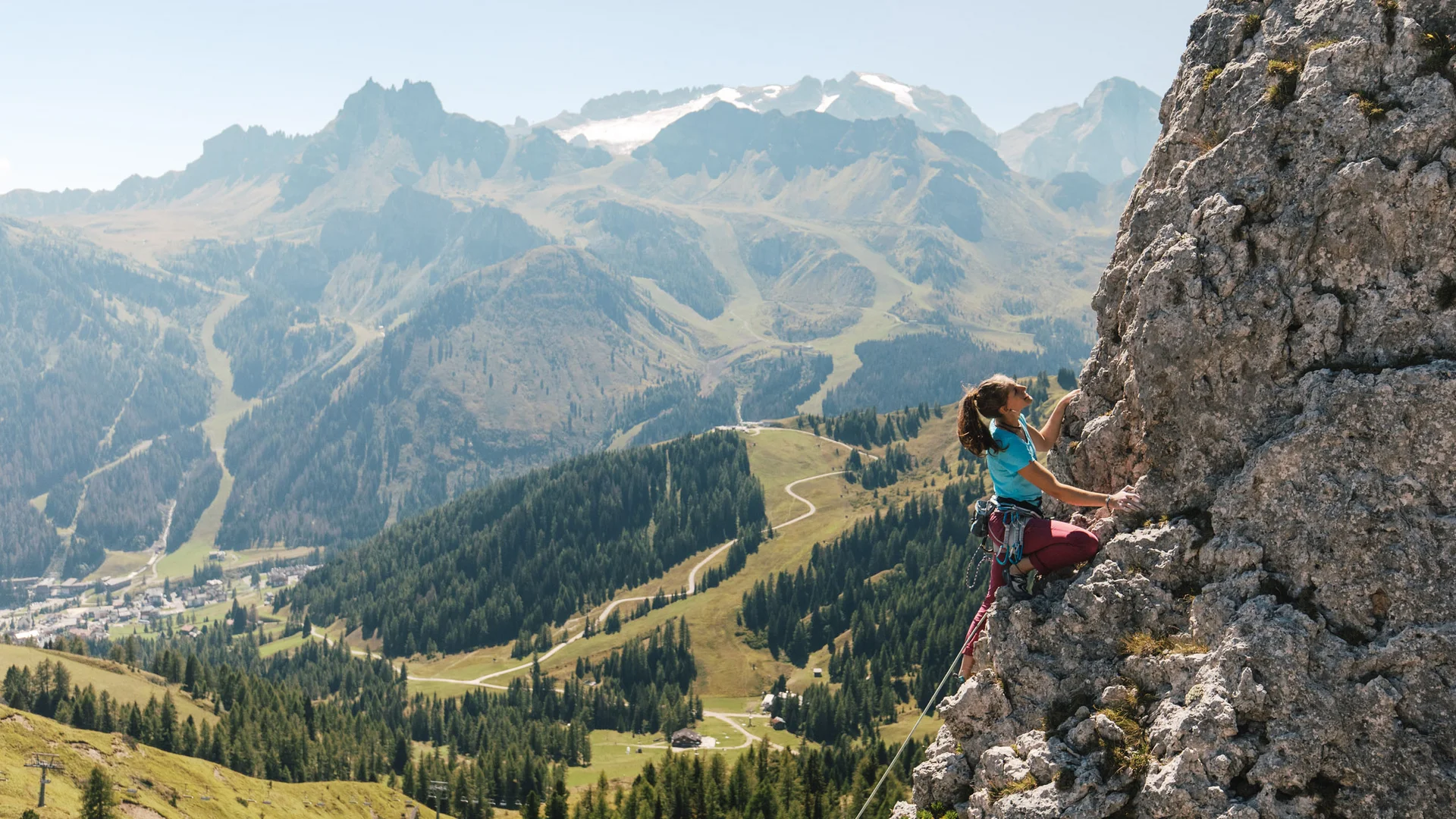 Bilder aus Arabba des Chalet Barbara Frau klettert an Felswand mit Bergen im Hintergrund