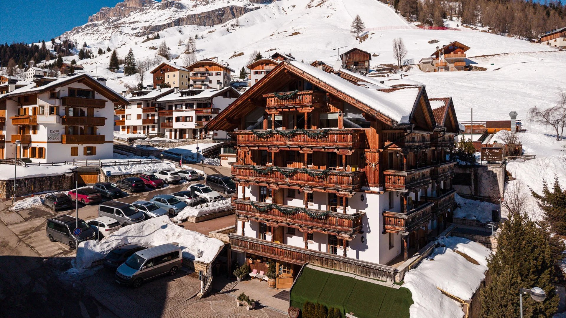 The story of our chalet in Arabba Wooden hotel with flowered balconies and snowy mountains in the background