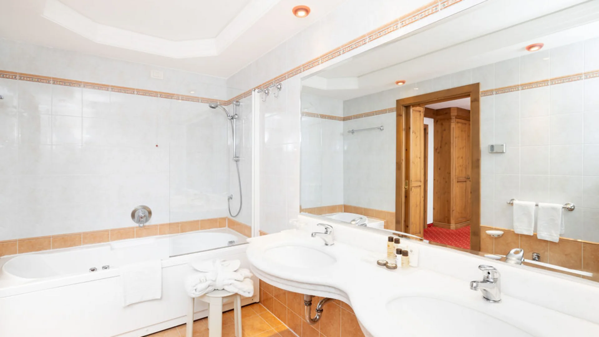 Bilder aus Arabba des Chalet Barbara Helles Badezimmer mit Badewanne, Doppelwaschbecken und weißen Handtüchern