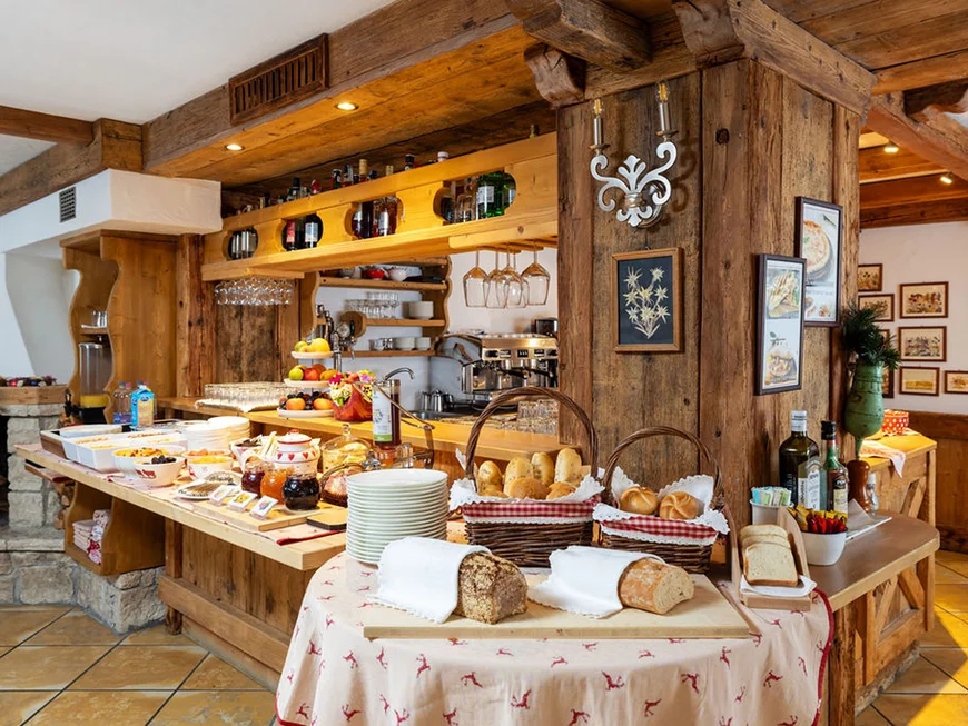 Frühstücksbuffet mit Brot, Marmeladen und Getränken in rustikalem Ambiente