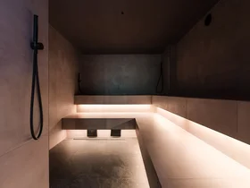 Interior of modern sauna with illuminated bench and wall-mounted showers