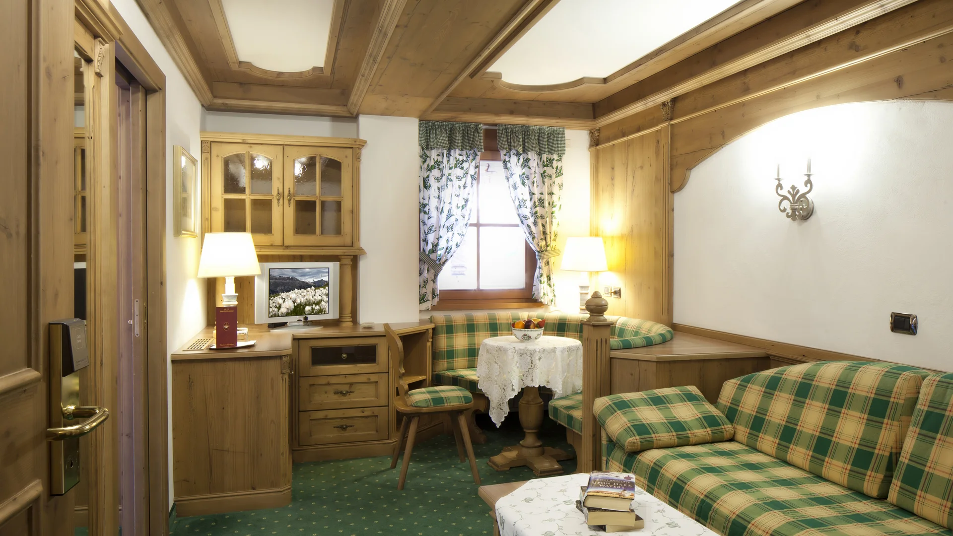 Bilder aus Arabba des Chalet Barbara Rustikales Wohnzimmer mit kariertem Sofa und Holzmöbeln