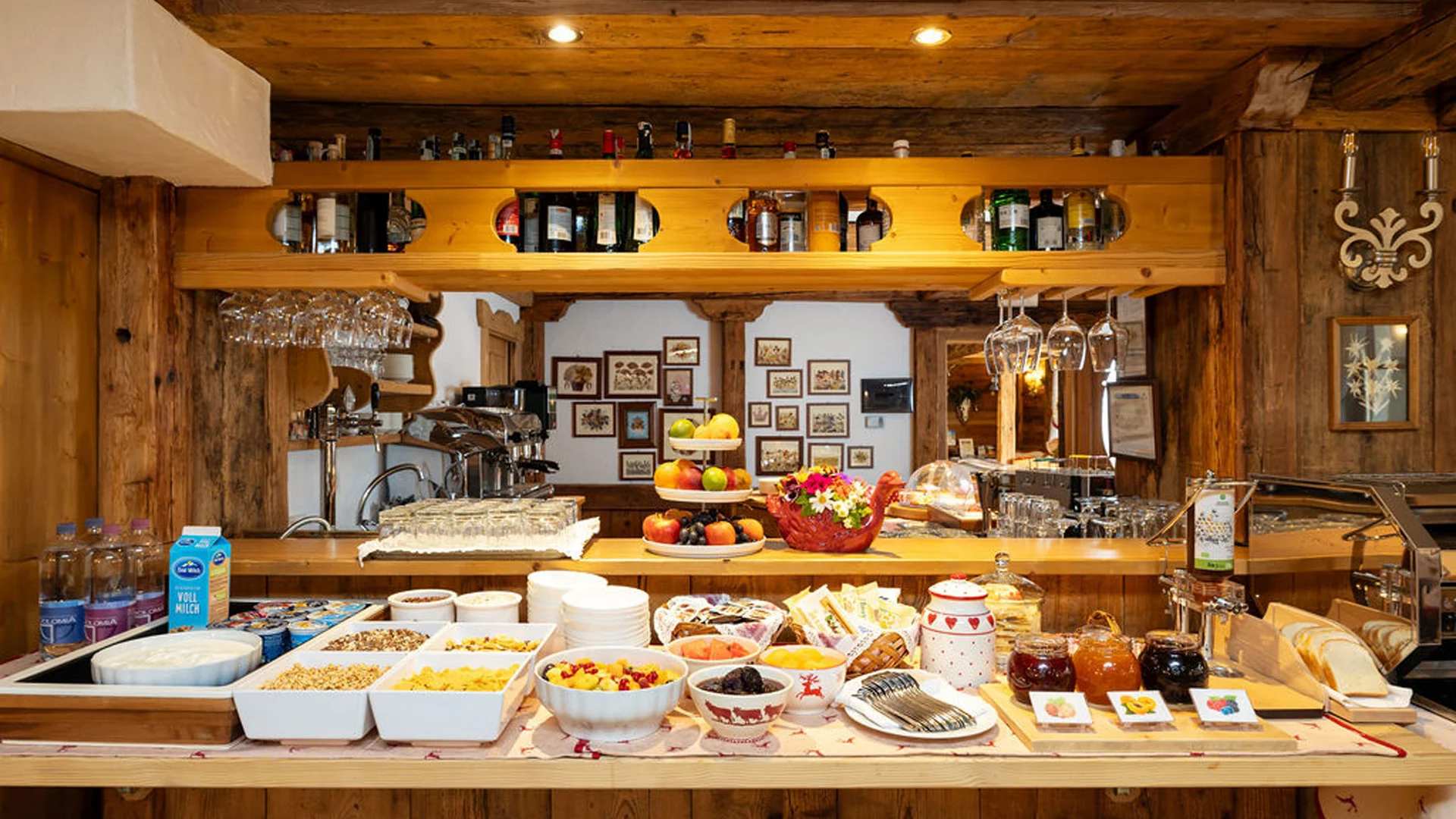 Bilder aus Arabba des Chalet Barbara Frühstücksbuffet mit Müsli, Obst, Marmelade und Getränken in rustikalem Ambiente