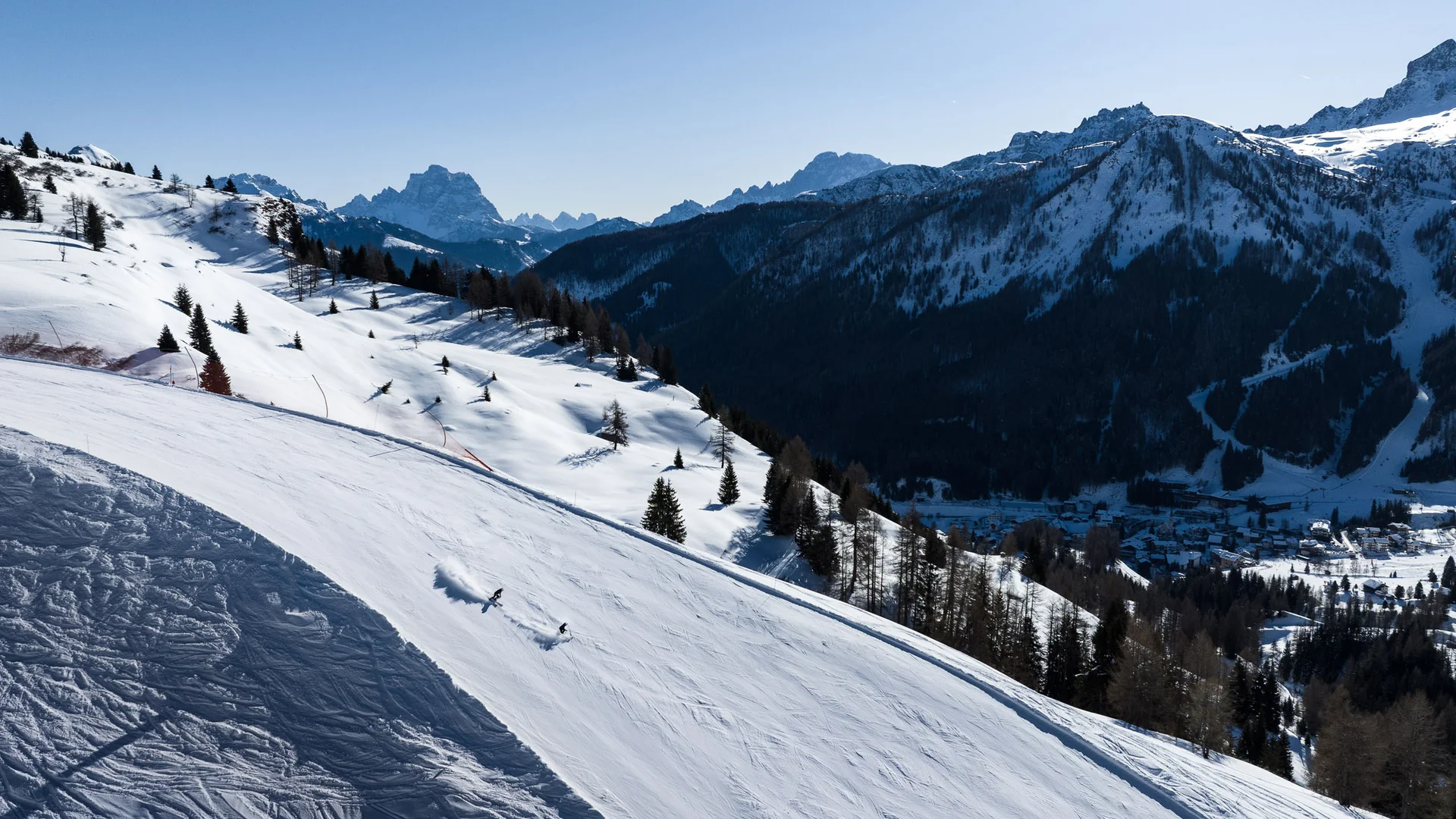 Bilder aus Arabba des Chalet Barbara Verschneite Skipiste mit Skifahrern und Bergen im Hintergrund